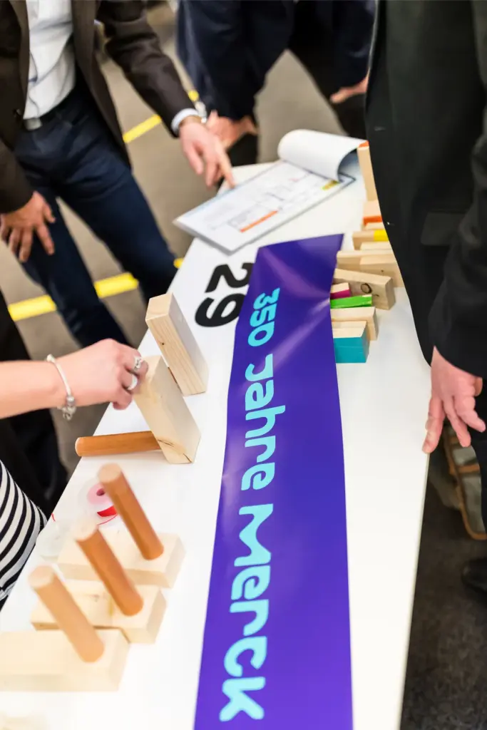 Merck-Team baut die XXL-Kettenreaktion am Tisch – Teamevent in Frankfurt (350 Jahre Merck)